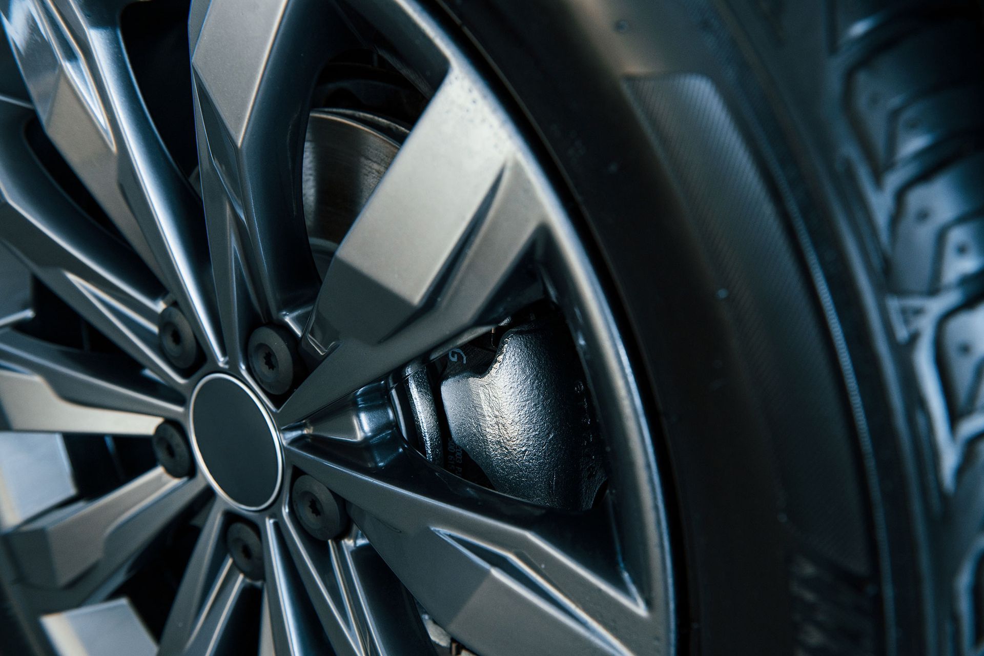 Close-up of a dark gray car wheel with tire and silver rim.